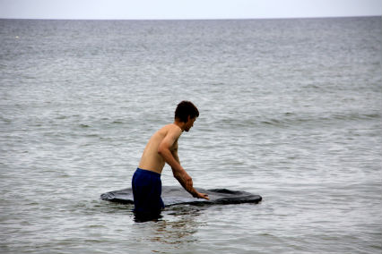 Vytautas Tautkevičius installing his work "Oil Spots" in the Baltic Sea, 2011 / Photo by Jūratė Jarulytė